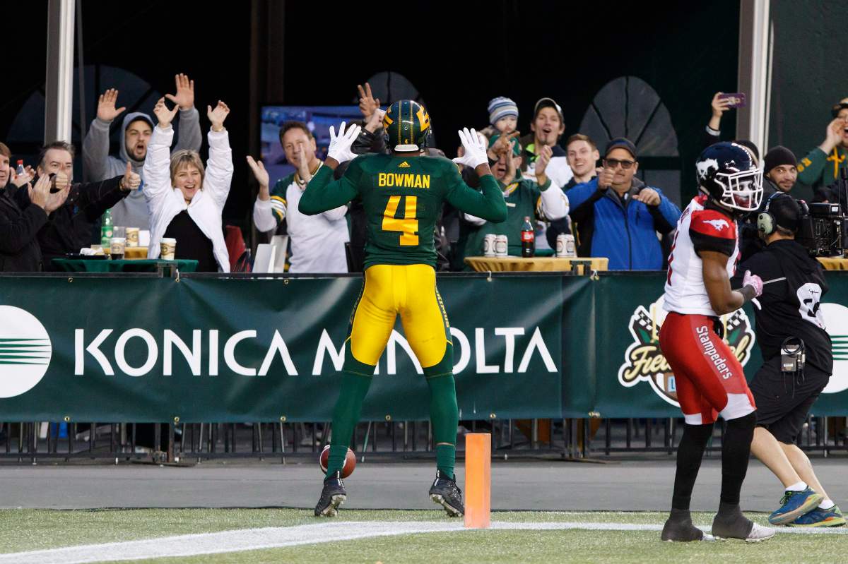 Calgary Stampeders' Joshua Bell (11) leaves the field as Edmonton Eskimos' Adarius Bowman (4) celebrates his touchdown during first half CFL action in Edmonton, Alta., on Saturday October 28, 2017. 