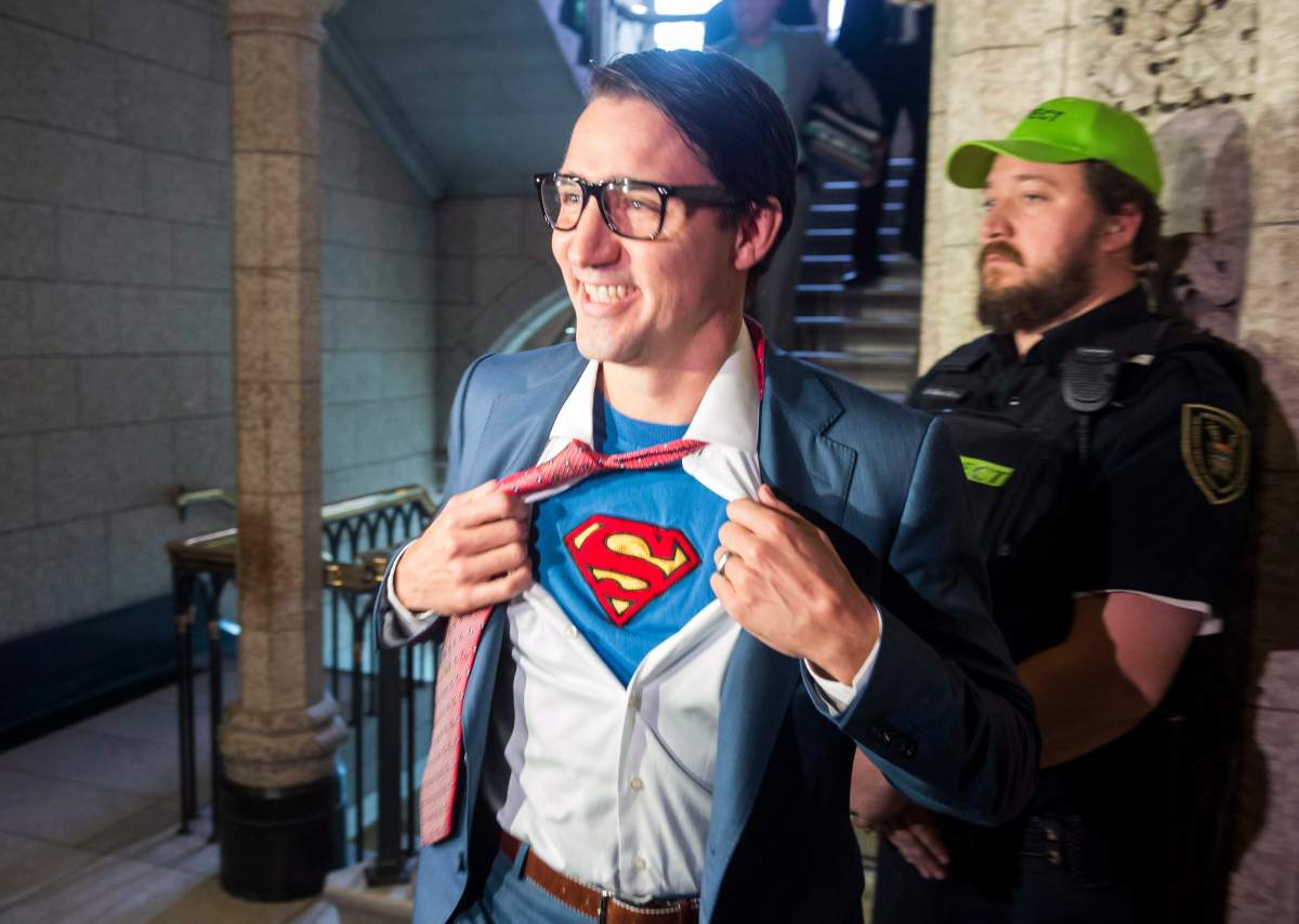 Prime Minister Justin Trudeau shows off his costume as Clark Kent, alter ego of comic book superhero Superman, as he walks through the House of Commons, in Ottawa on Tuesday, October 31, 2017.