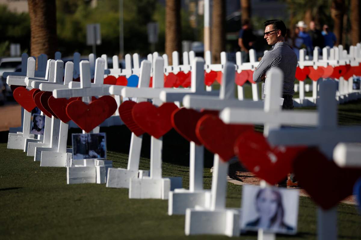 A man looks at the 58 white crosses set up for the victims of the Route 91 music festival mass shooting in Las Vegas, Nevada, U.S., October 5, 2017.