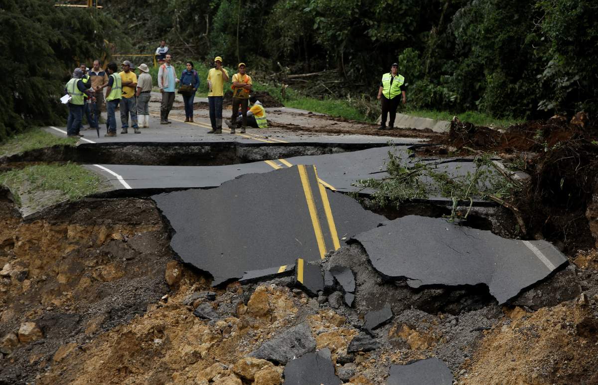 Workers gather near a highway collapsed by Hurricane Nate in Casa Mata, Costa Rica, on Oct. 6.