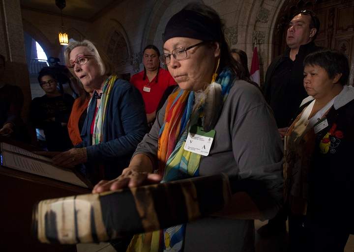 Chief Marcia Brown Martel touches her drum as Crown-Indigenous Relations and Northern Affairs Minister Carolyn Bennett responds to a question during a news conference on Parliament Hill, in Ottawa on Friday, October 6, 2017. Bennett announced a compensation package for indigenous victims of the sixties scoop.