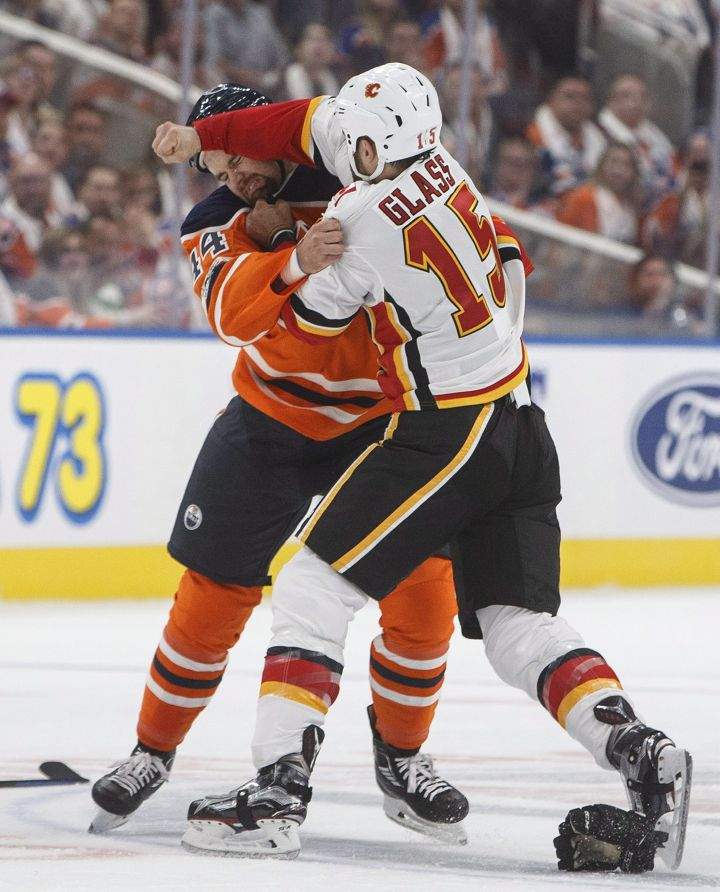 Calgary Flames’ Tanner Glass (15) and Edmonton Oilers’ Zack Kassian (44) fight during first period NHL action in Edmonton, Alta., on Wednesday October 4, 2017.