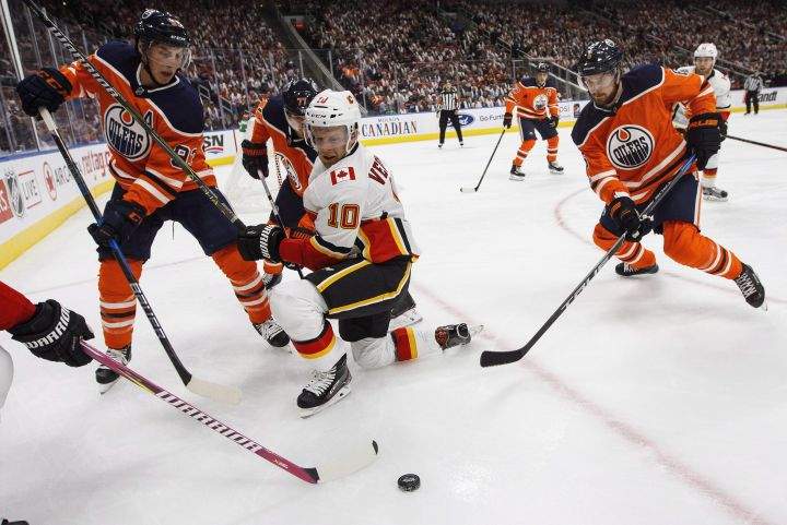Calgary Flames’ Kris Versteeg (10) battles in the corner with Edmonton Oilers’ Ryan Nugent-Hopkins (93) and Adam Larsson (6) during first period NHL action in Edmonton, Alta., on Wednesday October 4, 2017.