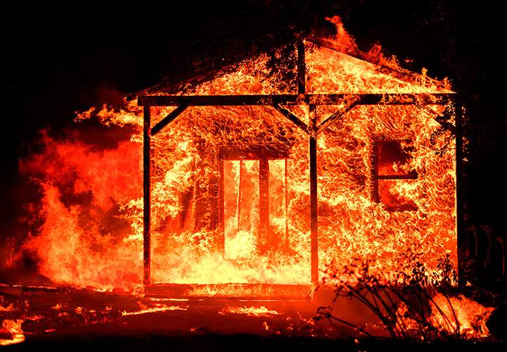 Flames overtake a structure as nearby homes burn in the Napa wine region in California on October 9, 2017.