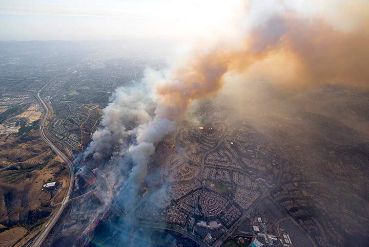 A wildfire moves closer to homes along the 261 freeway in Tustin, California, Monday, Oct. 9, 2017.
