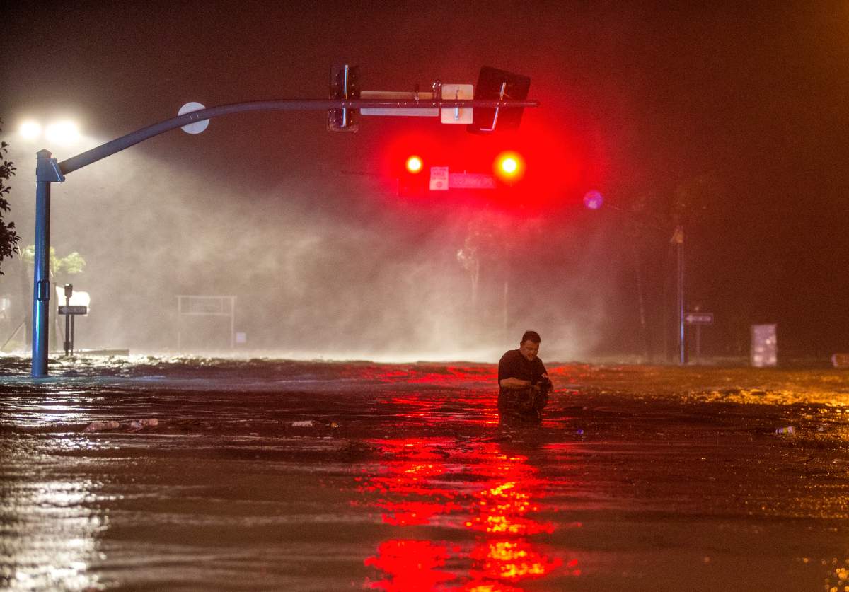 Lanny Dean, from Tulsa, Okla., takes video as he wades along the flooded Beach Boulevard next to Harrah’s Casino as the eye of Hurricane Nate pushes ashore in Biloxi, Miss., on Oct. 8.