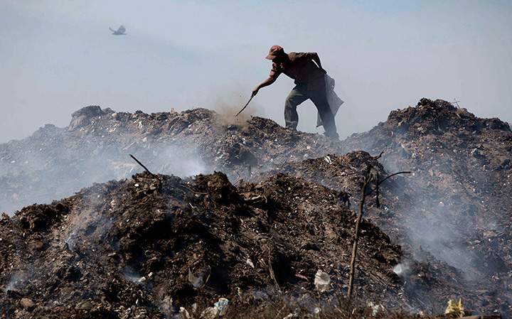 A man rummages through garbage heaps at the main landfill in Managua, Nicaragua in this Thursday Dec. 2, 2010 file photo. 