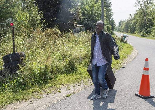 An asylum seekers, claiming to be from Eritrea, walks up to cross the border into Canada from the United States Monday, August 21, 2017 near Champlain, N.Y. 