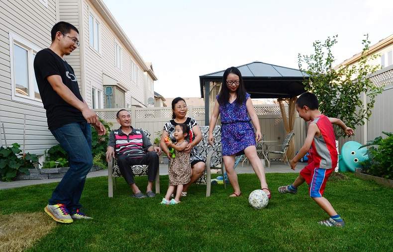 Yi Jiang, Jianqiao Sun, their son Sunny, their daughter Jenny and grandparents Youfang Jiang and Li Zhang are pictured at their home in Ottawa in July. The family immigrated to Canada from China and live together as a multi-family household.