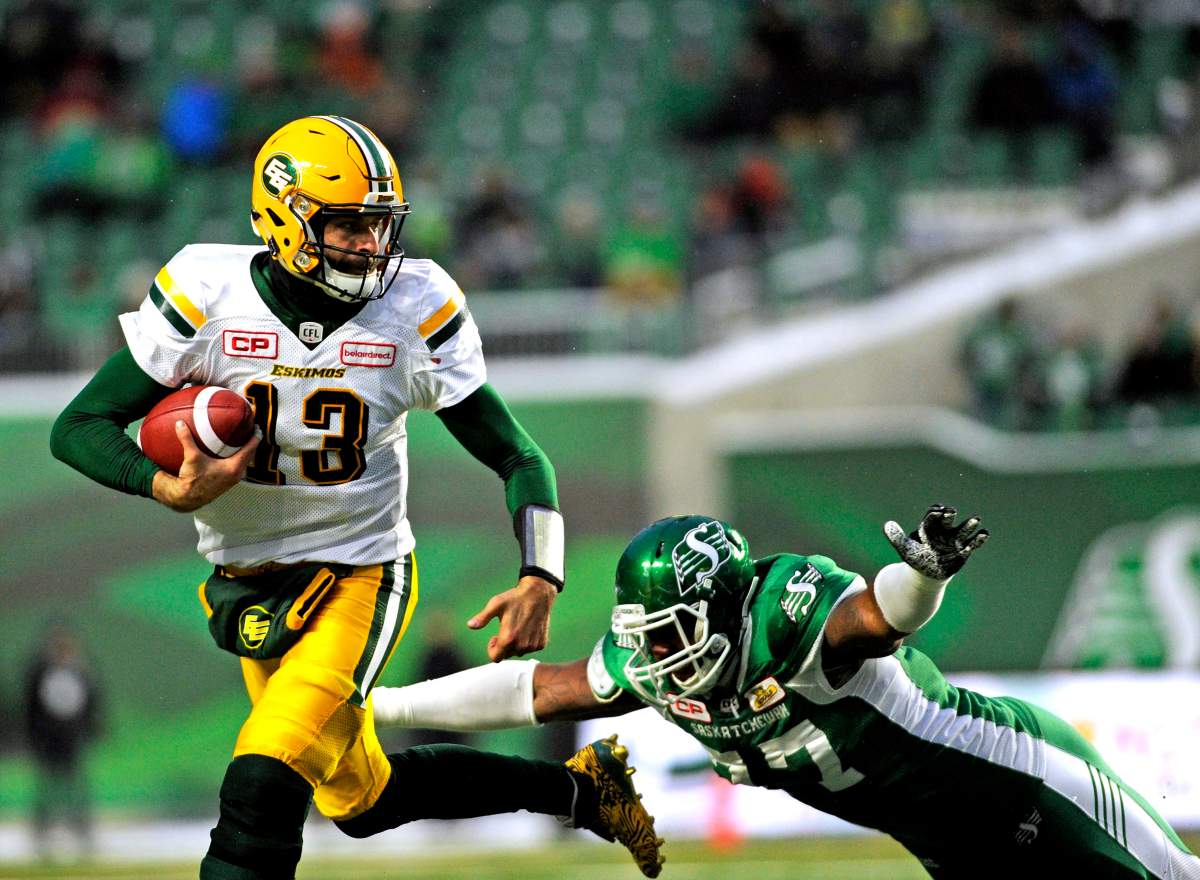 Edmonton Eskimos quarterback Mike Reilly runs the ball against Saskatchewan Roughriders' Rakim Cox during first half CFL football action at Mosaic Stadium in Regina on Saturday, November 4, 2017. 