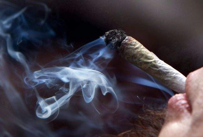 A young man smokes a marijuana joint during a rally in downtown Vancouver, B.C., April 20, 2011. 