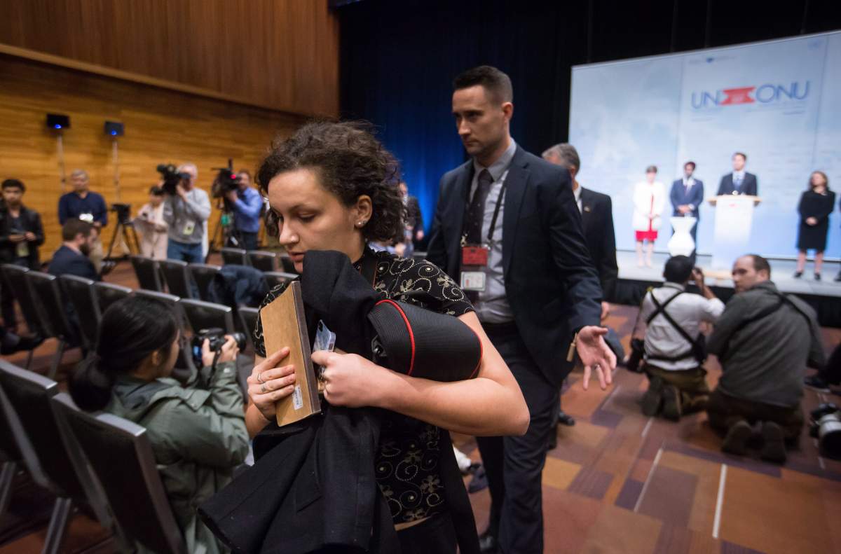 One of two protesters opposed to the Kinder Morgan Trans Mountain Pipeline expansion who interrupted Prime Minister Justin Trudeau’s news conference is escorted out by a member of the security detail during the 2017 United Nations Peacekeeping Defence Ministerial Conference in Vancouver, B.C., on Wednesday, Nov. 15, 2017.