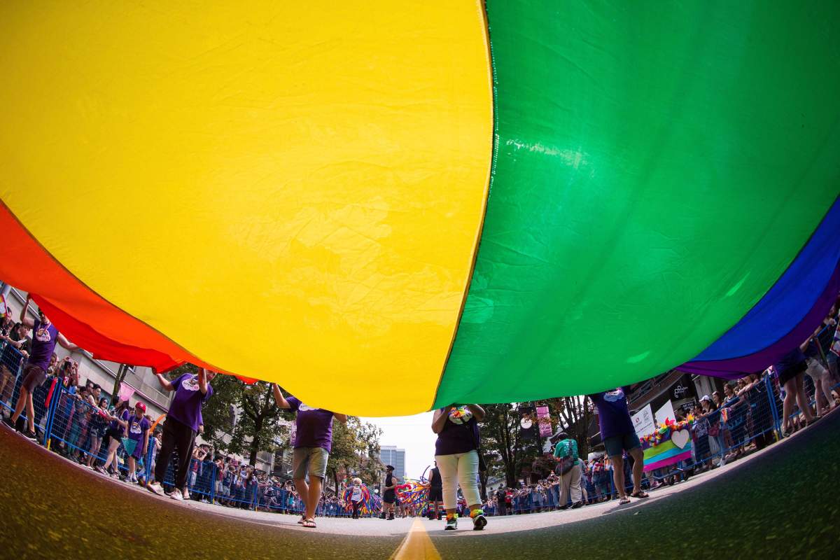 A giant rainbow flag is carried on Robson Street during the Vancouver Pride Parade on Aug. 6, 2017.