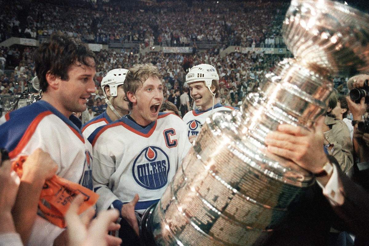 Edmonton Oilers captain Wayne Gretzky gets ready to hoist the Stanley Cup during the presentation in Edmonton, Alta. in this May 31, 1985 file photo. At left is Paul Coffey and at right is Mike Krushilnyski. It hardly seems possible that two decades have slipped away since the memorable march of the Edmonton Oilers to a second straight Stanley Cup.