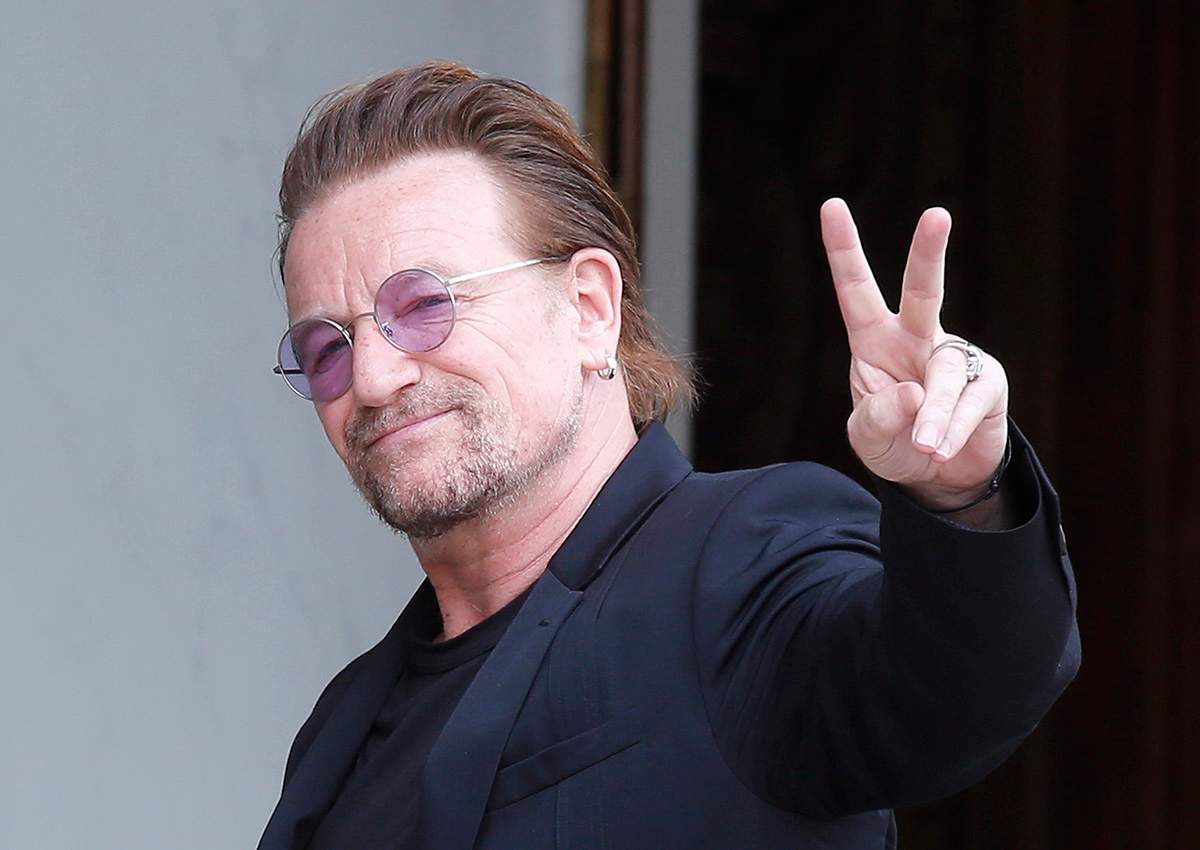 In this Monday, July 24, 2017 file photo, U2 singer Bono makes a peace sign as he arrives for a meeting at the Elysee Palace, in Paris, France. 