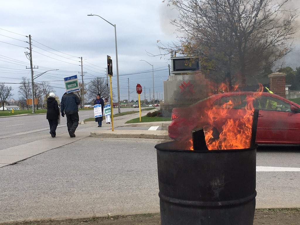 A barrel burns as striking faculty walk the picket lines at Fanshawe College's front entrance on Nov. 1, 2017.
