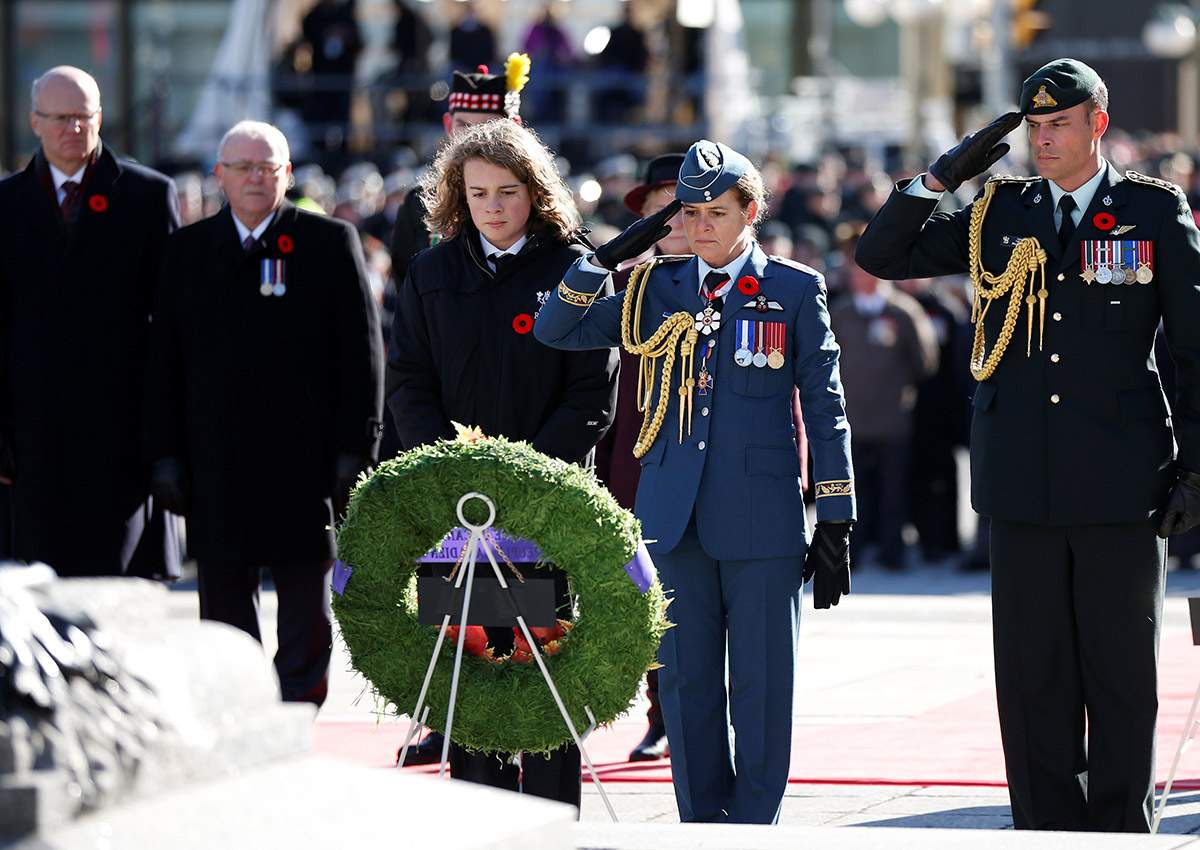 Canada’s Governor General Julie Payette (2nd R) salutes after laying a wreath with her son Laurier Payette Flynn (L) during Remembrance Day ceremonies at the National War Memorial in Ottawa, on Nov. 11, 2017.