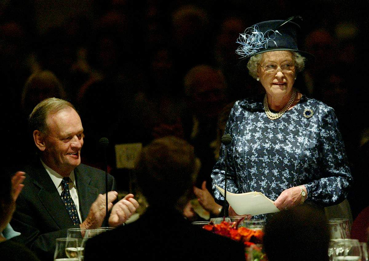 Canadian Prime Minister Jean Chretien listens to a speech by Queen Elizabeth during a luncheon in Vancouver October 7, 2002. 