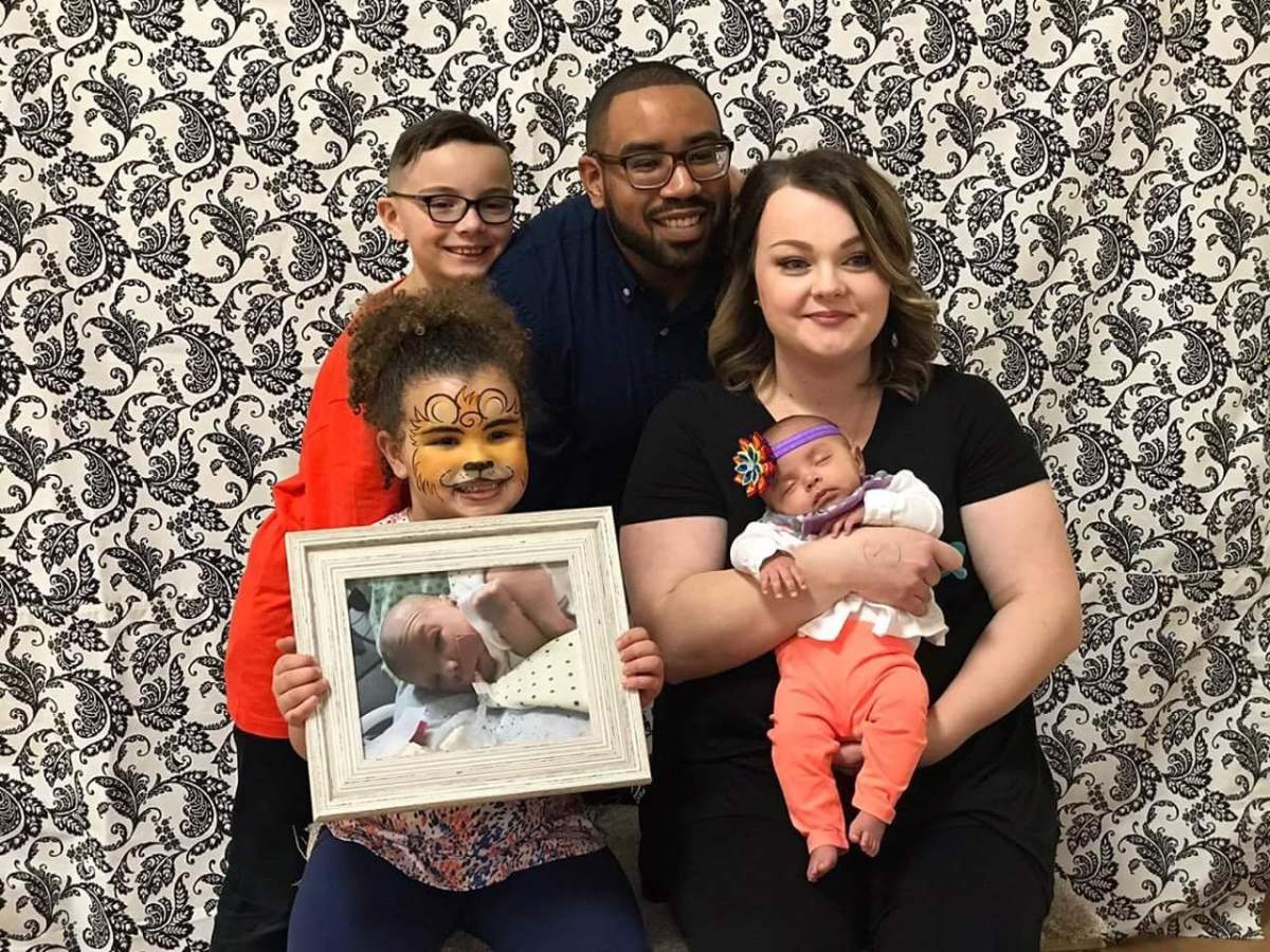 Brea Dean, bottom left, with brother Kaynen, father Dustin, mother Lisa and sister Maliyah, holds a photo of Aydrah.