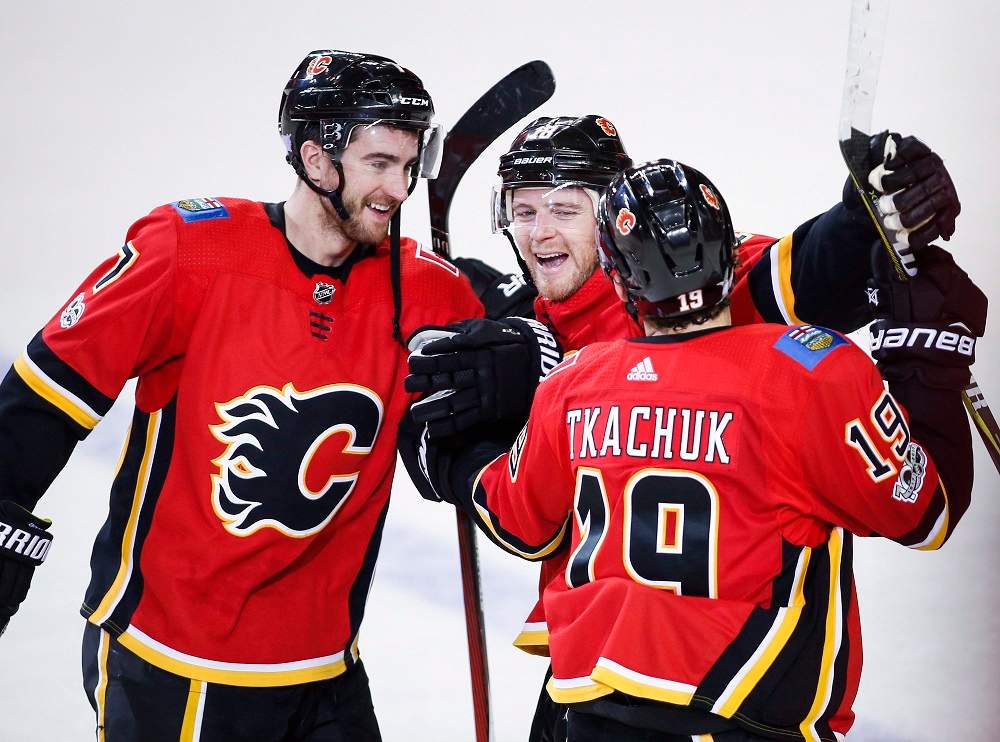 Calgary Flames' Matthew Tkachuk, right, celebrates his game-wiinning shootout goal with teammates Matt Stajan, centre, and T.J. Brodie during overtime NHL hockey action against the New Jersey Devils in Calgary, Sunday, Nov. 5, 2017.THE CANADIAN PRESS/Jeff McIntosh.