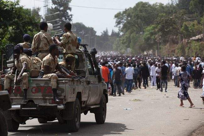 Oromo regional police officers wait in a pick up car during the Oromo new year holiday Irreechaa in Bishoftu on October 2, 2016.
Several people were killed in a stampede near the Ethiopian capital on October 2, according to an AFP photographer at the scene. Several thousand people from the Oromo community gathered at a sacred lake for a religious festival and started to cross their wrists above their heads, a symbol of Oromo anti-government protests. The event quickly degenerated, with protesters throwing stones and bottles and security forces responding with baton charges and tear gas grenades. Together, Oromos and Amharas make up 60 percent of the population and have become increasingly vocal in rejecting what they see as the disproportionate power wielded by the northern Tigrean minority in government and the security forces. / AFP / Zacharias ABUBEKER        (Photo credit should read ).