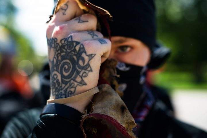 An Antifa demonstrator holds up the remains of a tattered and burned US national flag during a protest in Denver, Colorado on June 10, 2017.