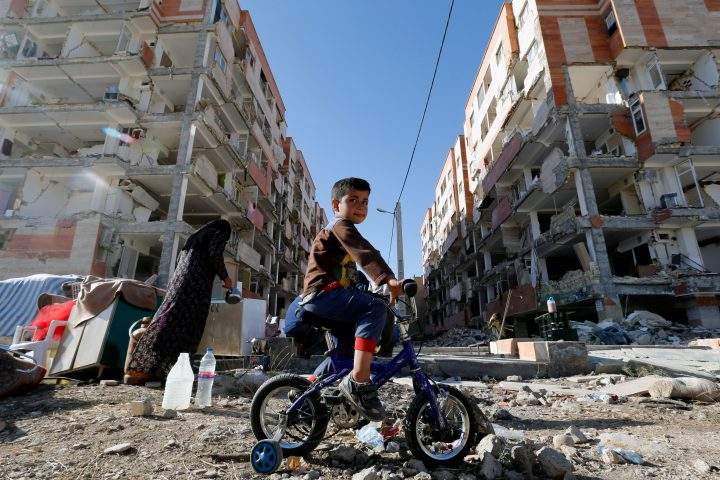An Iranian boy rides a bicycle through the rubble caused by a 7.3-magnitude earthquake that left hundreds killed in November. 