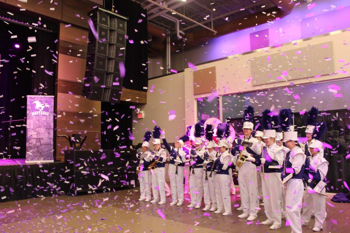 A burst of confetti falls around the marching band, towards the end of campus festivities.