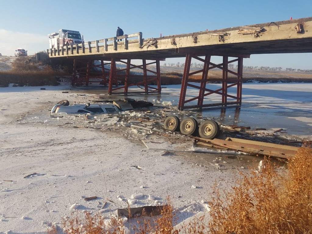 A truck and its trailer sit in a river near Carman, Man.