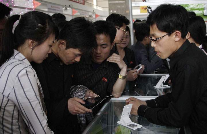 North Koreans looking at a tablet computer