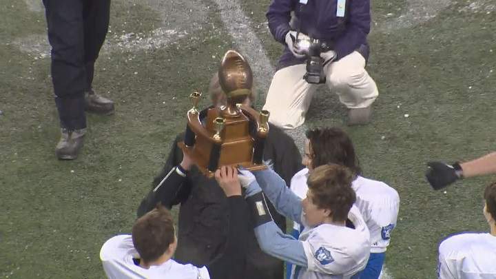 The Oak Park Raiders hoist the championship trophy after winning the Home Run Sports Bowl for the junior varsity title.