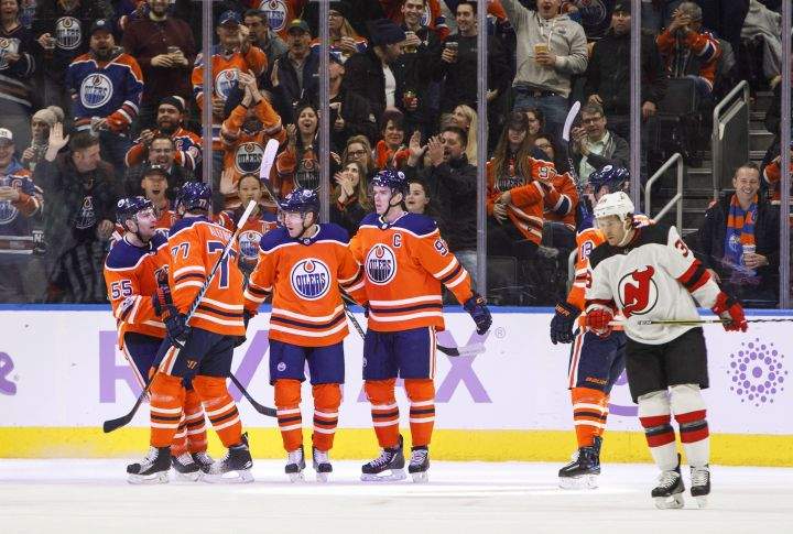 New Jersey Devils' Brian Gibbons (39) skates past as the Edmonton Oilers celebrate a goal during first period NHL action in Edmonton on Friday, November 3, 2017. 