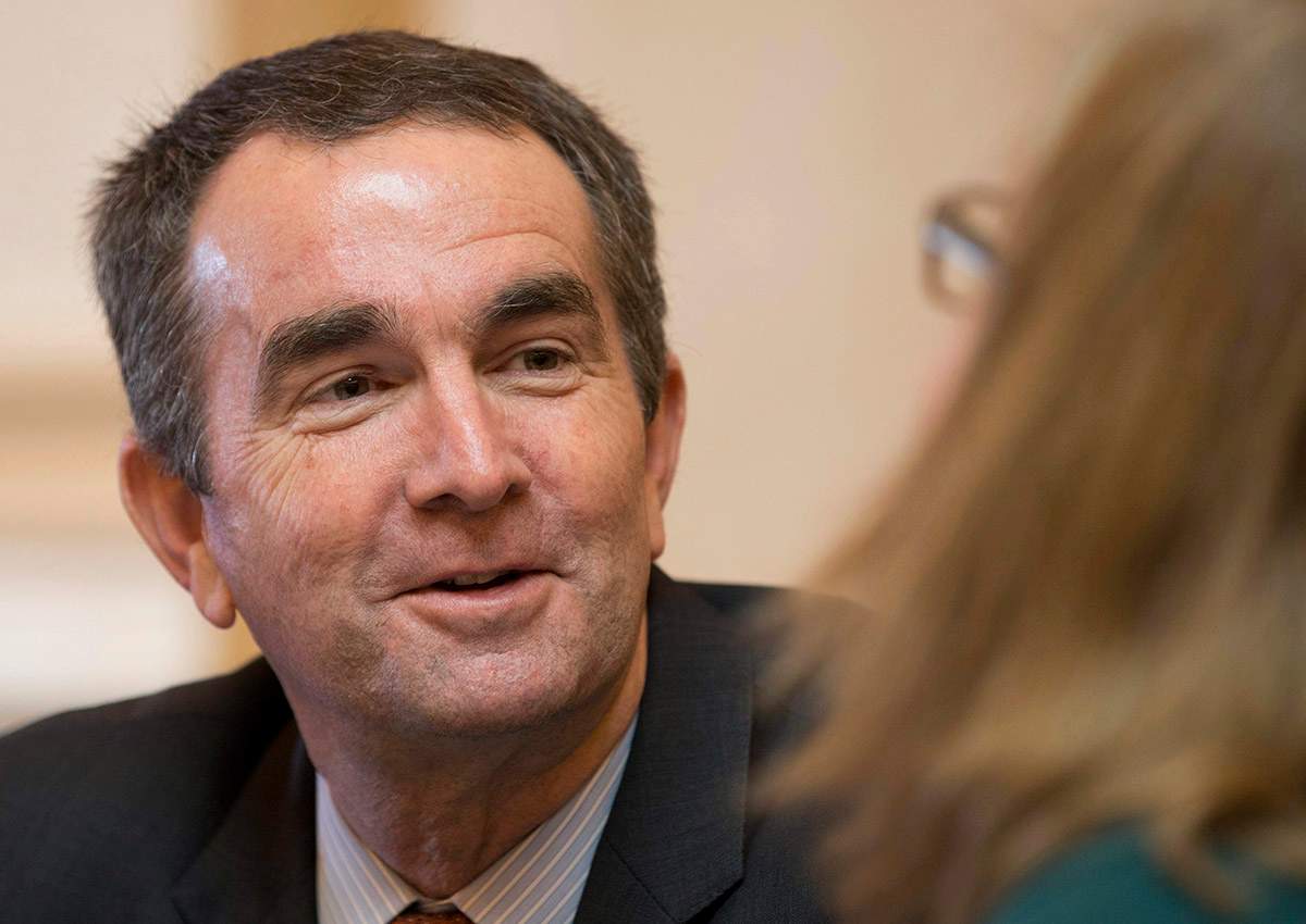 In this Jan. 26, 2016, file photo Virginia Lt. Gov., and Democratic candidate for Governor, Ralph Northam, left, talks with Senate Chief Deputy Clerk, Tara Perkinson, right, prior to the start of the Senate session at the Capitol in Richmond, Va.