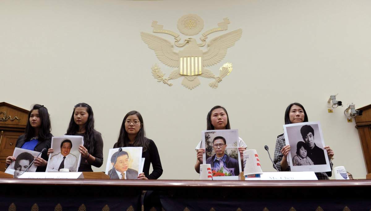 From left, Lisa Peng, holding a photo of her father Peng Ming, Grace Ge Geng, holding photo of her father Gao Zhisheng, Ti-Anna Wang, holding photo of her father Wang Bingzhang, Bridgette Chen holding photo of her father Liu Xianbing, and Danielle Wang, holding photo of her father Wang Zhiwen, are introduced prior to testifying before the House Foreign Affairs Committee hearing entitled, "Their Daughters Appeal to Beijing: 'Let Our Fathers Go,! on Capitol Hill in Washington, Thursday, Dec. 5, 2013.