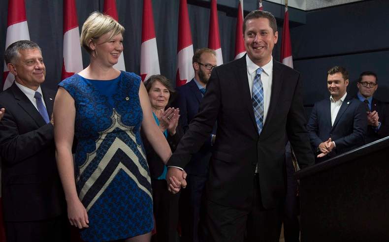 Andrew and Jill Scheer leave an announcement surrounded by Members of Parliament Wednesday September 28, 2016 in Ottawa. THE CANADIAN PRESS/Adrian Wyld