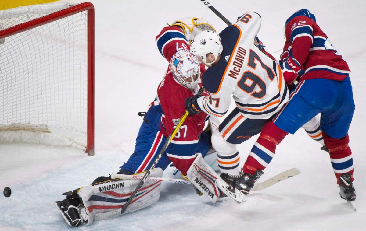 Edmonton Oilers' Connor McDavid (97) moves in on Montreal Canadiens goaltender Antti Niemi as Canadiens' Byron Froese defends during second period NHL hockey action in Montreal, Saturday, December 9, 2017. THE CANADIAN PRESS/Graham Hughes.