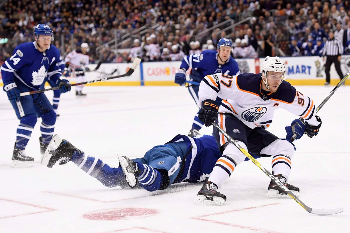 Edmonton Oilers centre Connor McDavid (97) drives to the net past sprawling Toronto Maple Leafs defenceman Ron Hainsey (2) during first period NHL hockey action in Toronto on Sunday, December 10, 2017. THE CANADIAN PRESS/Frank Gunn.