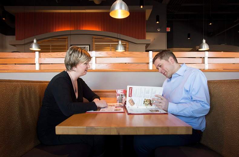 Andrew Scheer, right, looks over a menu with his wife Jill at a restaurant in Ottawa on Monday Dec. 11, 2017.
