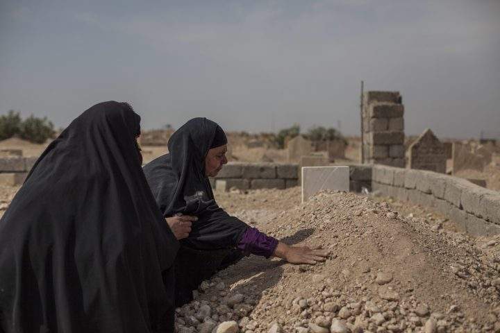 Fatima Ahmed Aswad cries as she touches the grave of her 15-year-old daughter Sana in Mosul on Oct. 9, 2017.