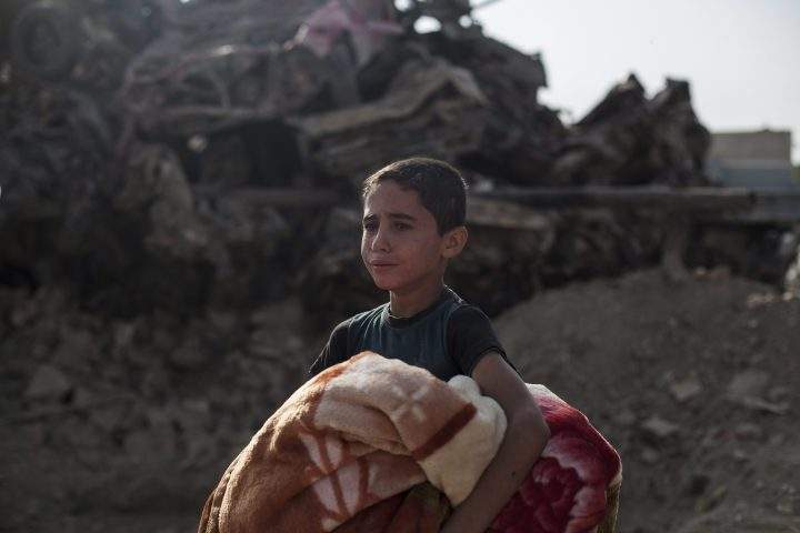 In this Oct. 9, 2017, Osama Younes cries as the body of his 15-year-old sister Sana is exhumed for forensic investigation in Mosul.