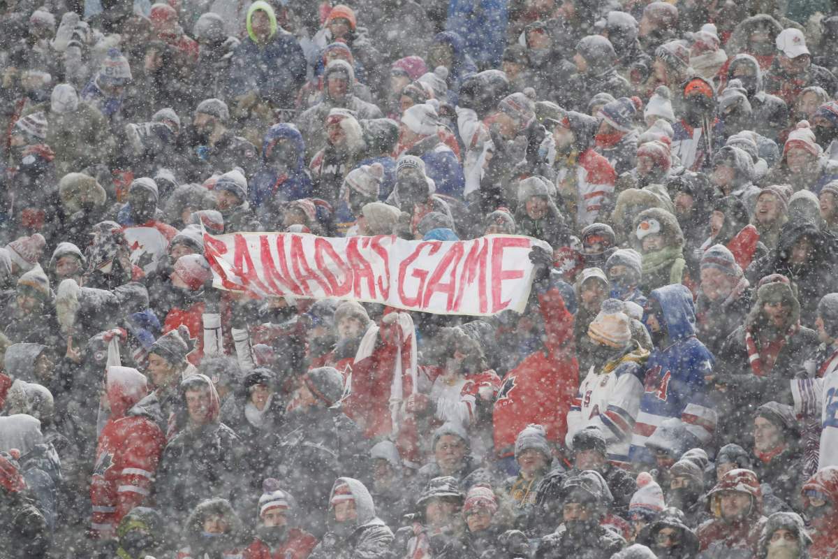 Hockey fans hold up a sign in the stands during the heavy snowfall at the IIHF World Junior Championship outdoor game between Canada and the U.S. at New Era Field in Orchard Park, N.Y., on Dec. 29, 2017. 