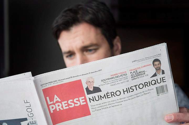 A man reads the final print edition of the French language newspaper La Presse at a coffee shop in Vaudreuil-Dorion, west of Montreal, Saturday, December 30, 2017. 