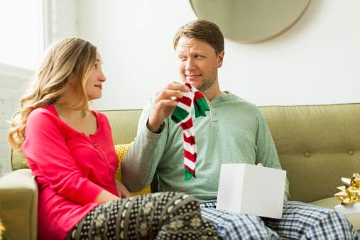 Man holding unwanted Christmas gift.