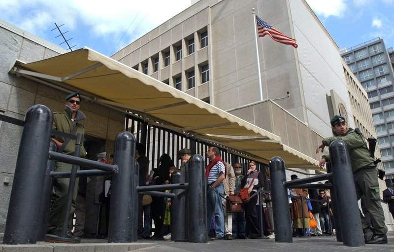 In this March 17, 2003, file photo, an Israeli border policemen guards the U.S. Embassy in Tel Aviv as other Israelis line up for U.S. visas. U.S. officials say U.S. President Donald Trump is poised to again delay his campaign promise to move the U.S. Embassy in Israel from Tel Aviv to Jerusalem. 