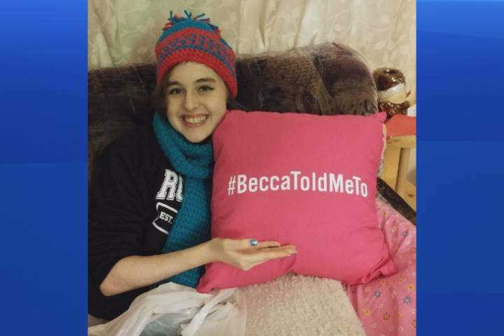 Becca Schofield, a Riverview, N.B., teenager battling terminal brain cancer, holds a pillow with a hashtag she asked people to use when they performed acts of kindness in her honour.