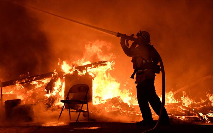 Firefighters battle flames from a Santa Ana wind-driven brush fire dubbed the Thomas Fire in Santa Paula, California, December 4, 2017.