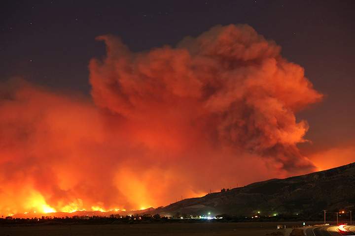 Smoke rises into the night sky as strong winds push the Thomas Fire across thousands of acres near Santa Paula, California, December 4, 2017.