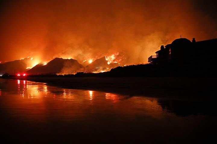 A wildfire burns along the 101 Freeway Tuesday, Dec. 5, 2017, in Ventura, Calif.