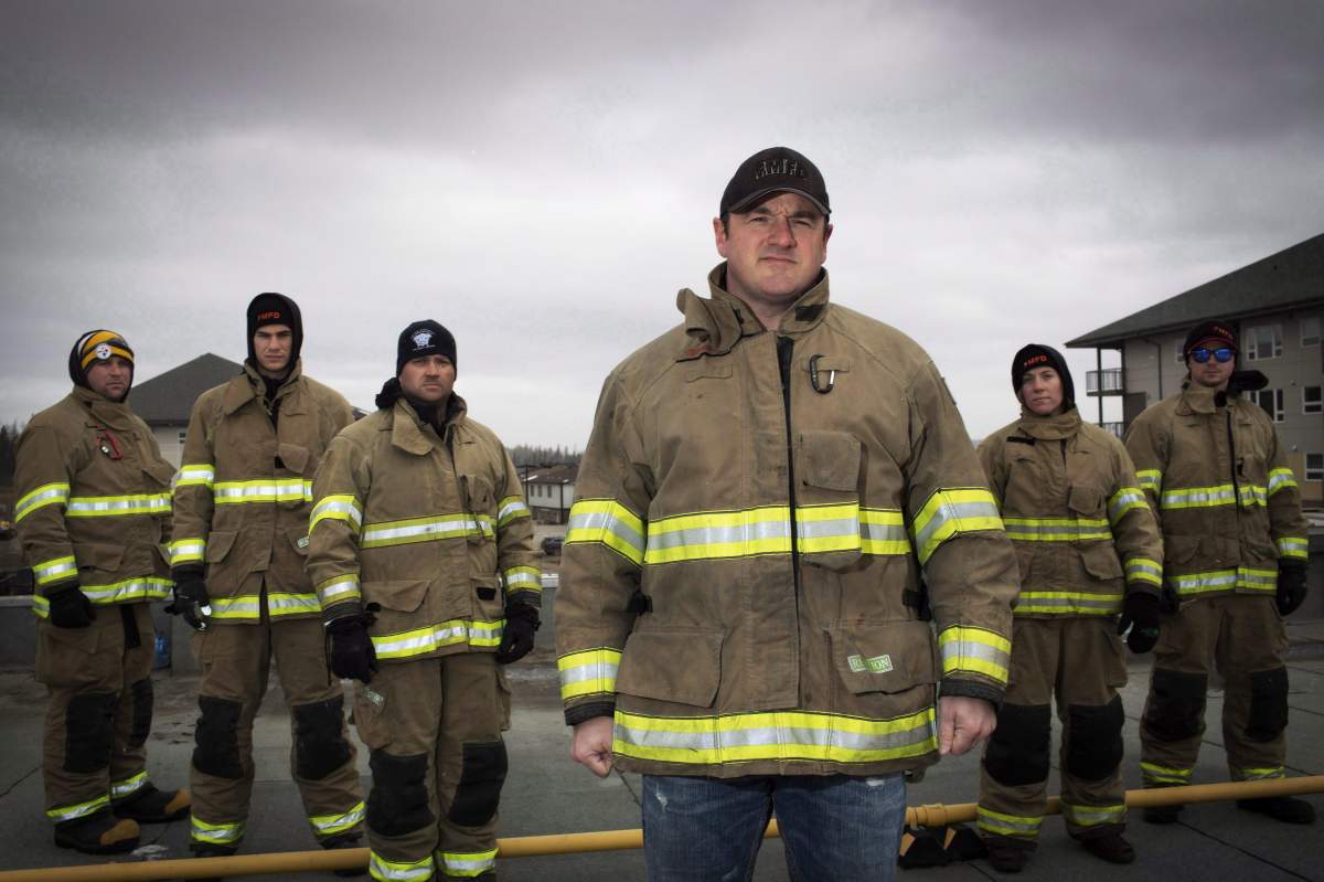 Firefighter Mark Stephenson (C) with fellow firefighters raising money at a charity event, filmed his house burning in the Abasand neighbourhood last year during the wildfires in Fort McMurray, Alta. Friday, April 22, 2017. 