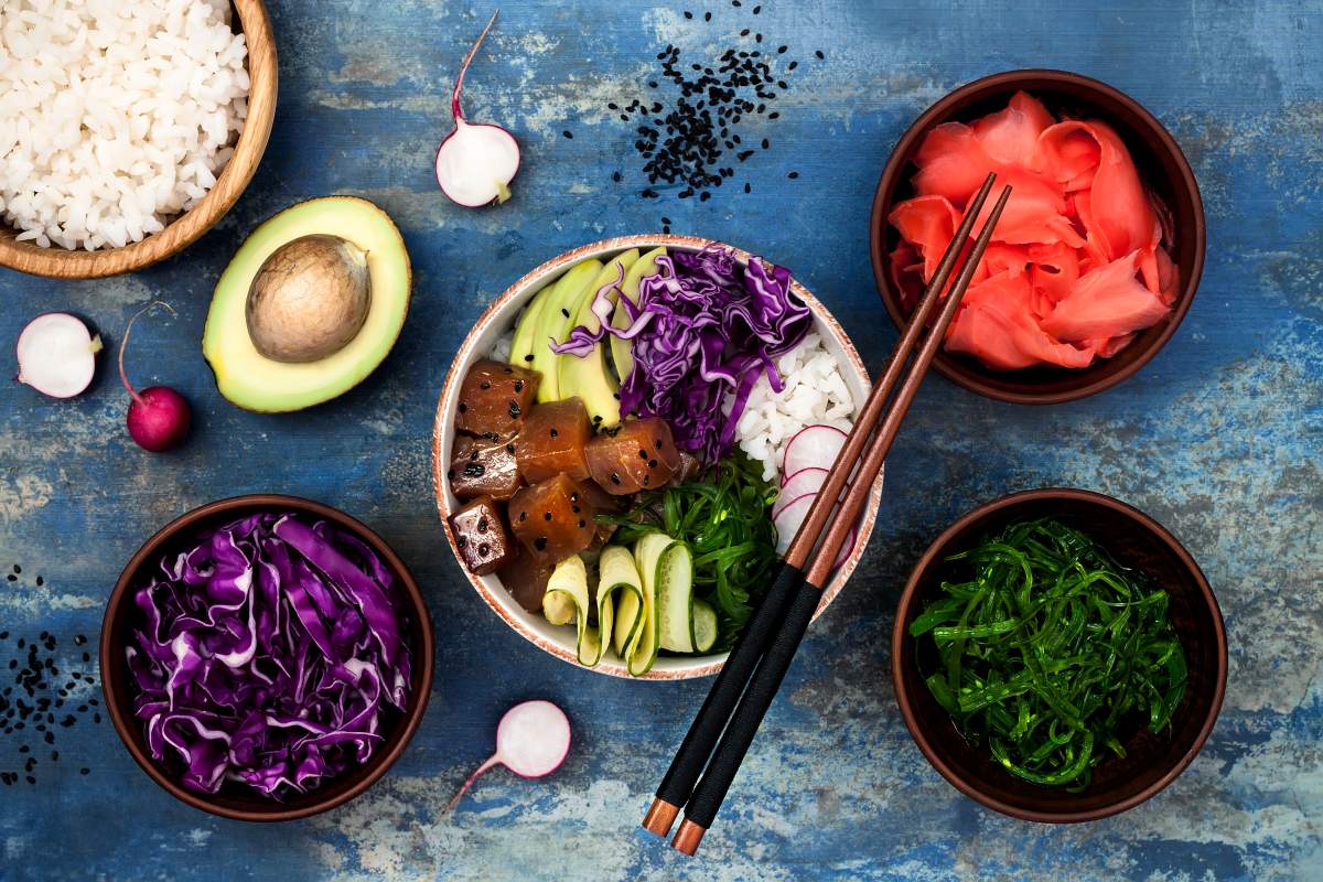 Hawaiian tuna poke bowl with seaweed, avocado, red cabbage slaw, radishes and black sesame seeds.